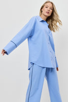 Woman wearing a blue pajama set on a white background