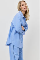 Woman wearing a light blue pajama set against a white background