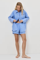Woman wearing a blue pajama set on a white background