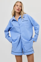 Woman wearing a blue pajama with shorts on a white background
