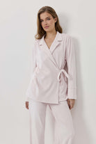 Woman wearing a light pink suit against a white background