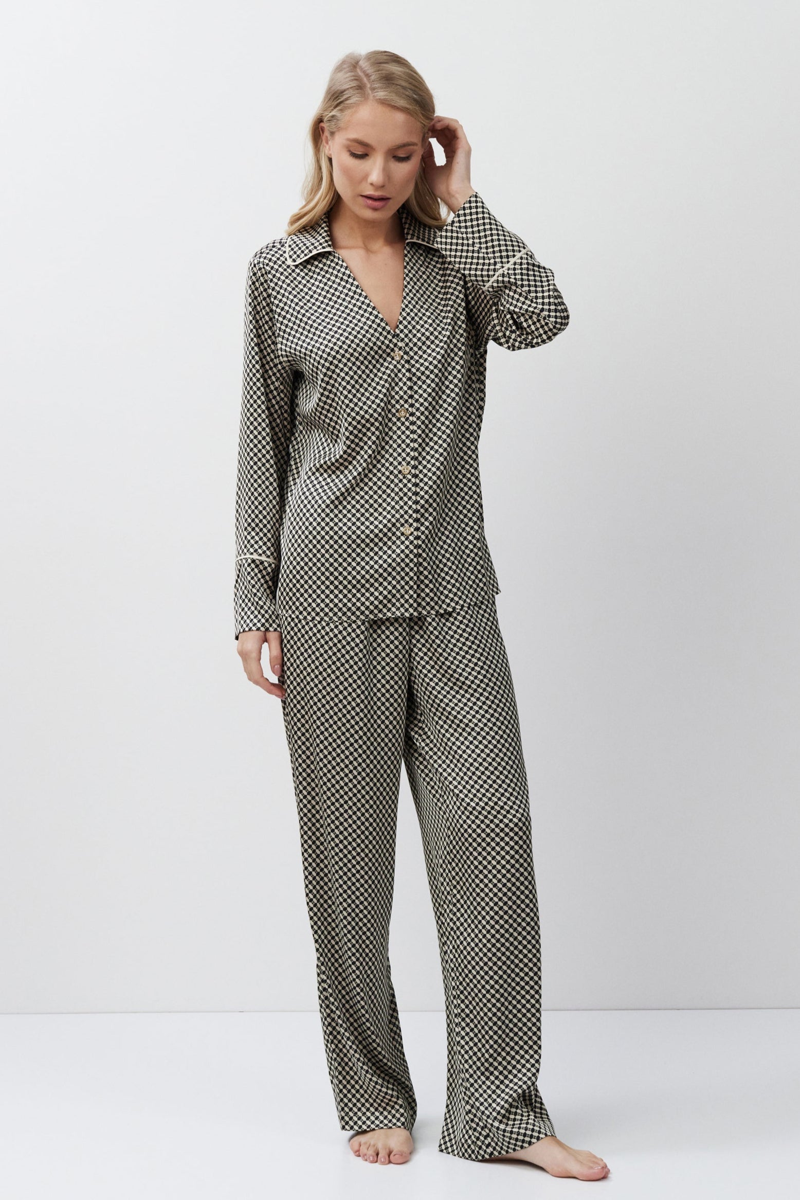 Woman wearing a checkered pajama set on a white background