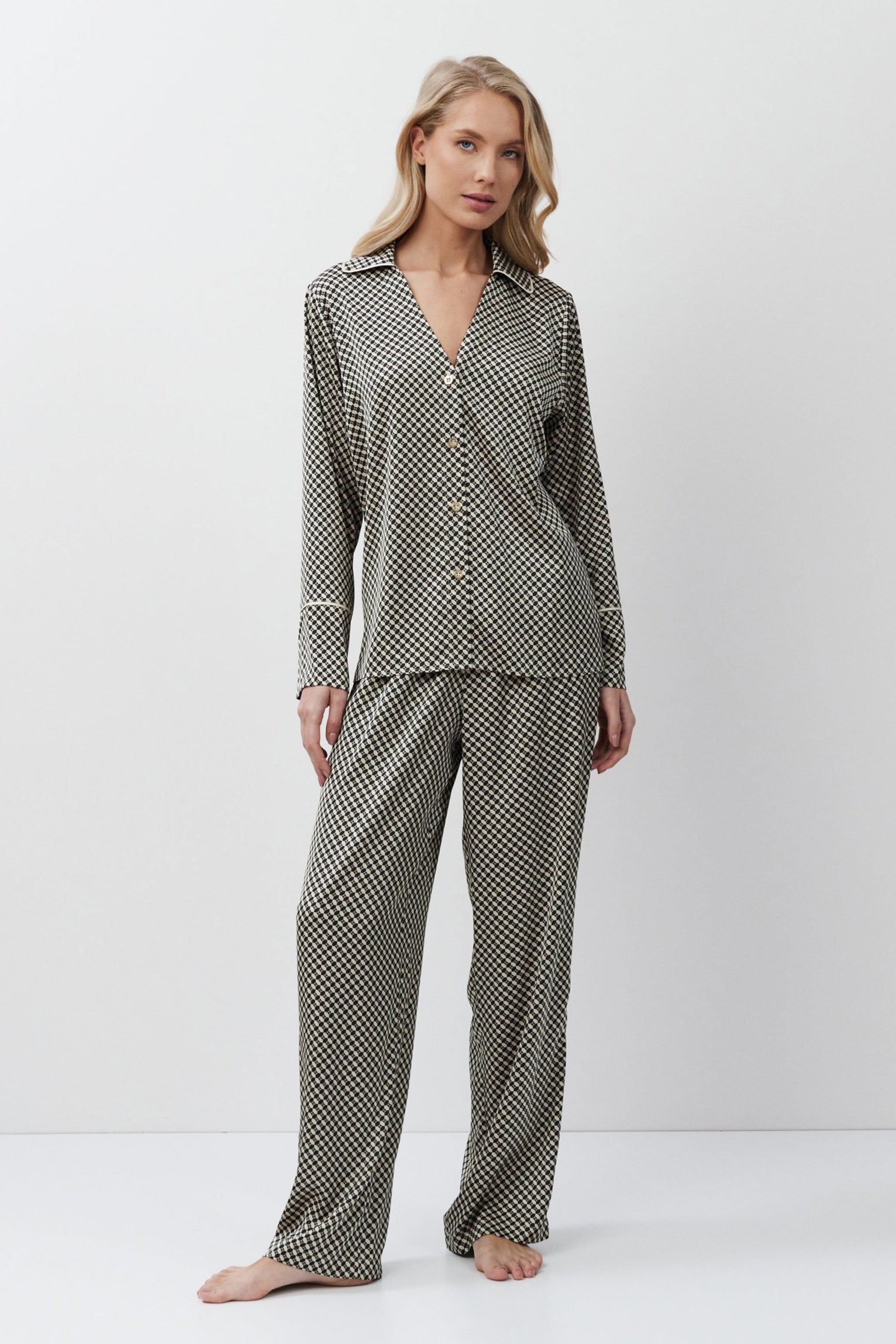 Woman wearing a patterned pajama set on a white background