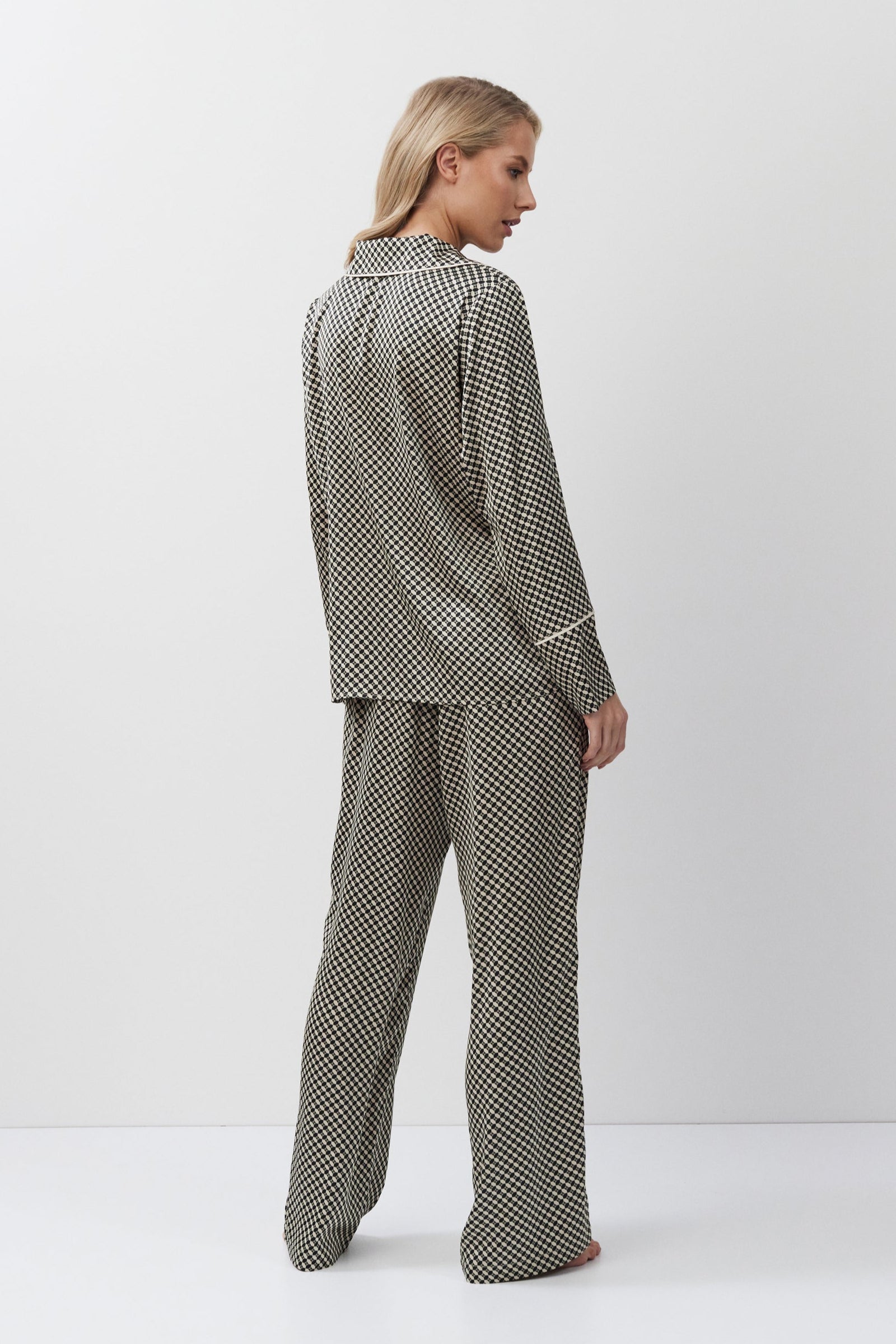 Woman wearing a patterned pajama set on a white background