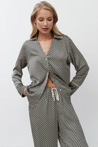 Woman wearing a patterned pajama set on a white background
