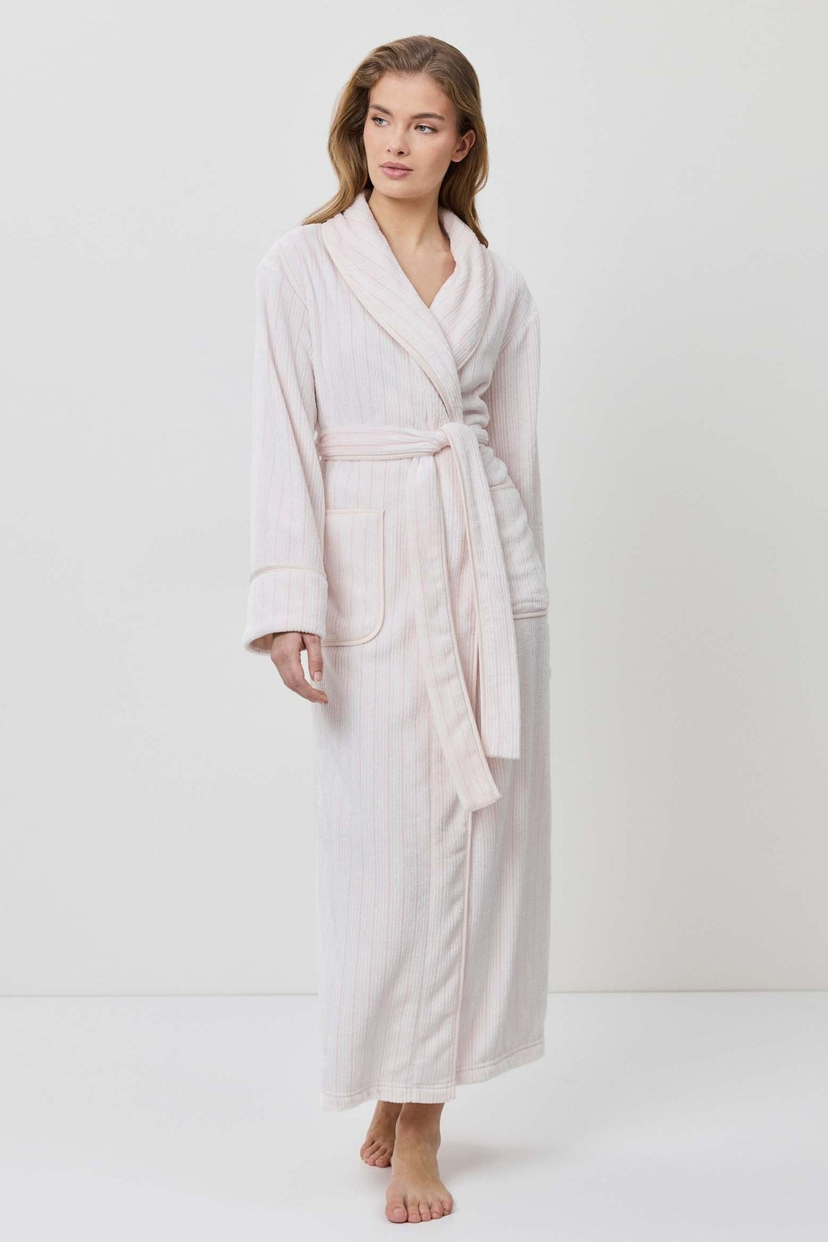 Woman wearing a beige robe on a white background