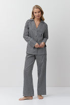 Woman wearing a black and white striped pajama set on a white background