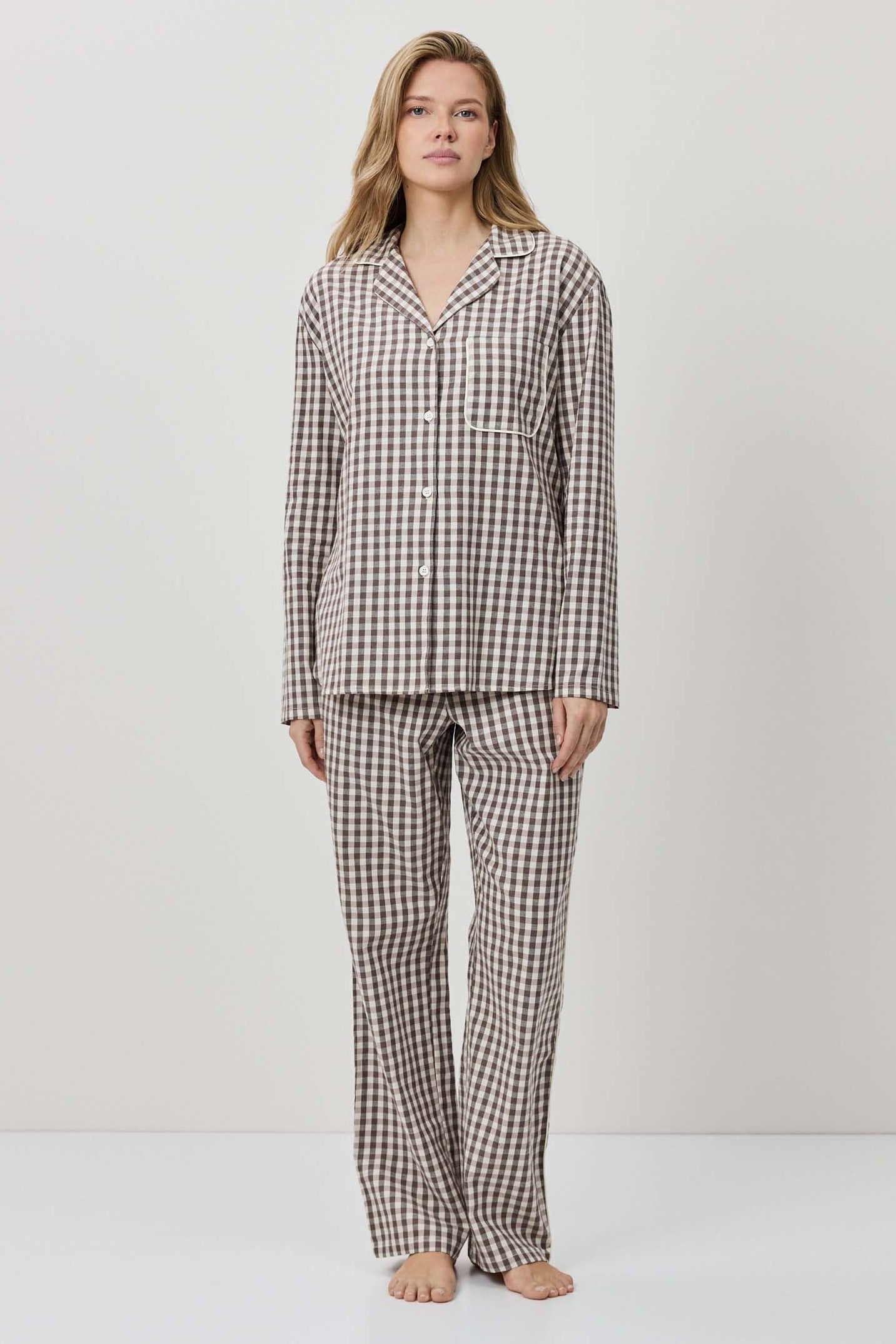 Woman wearing a checkered pajama set against a white background