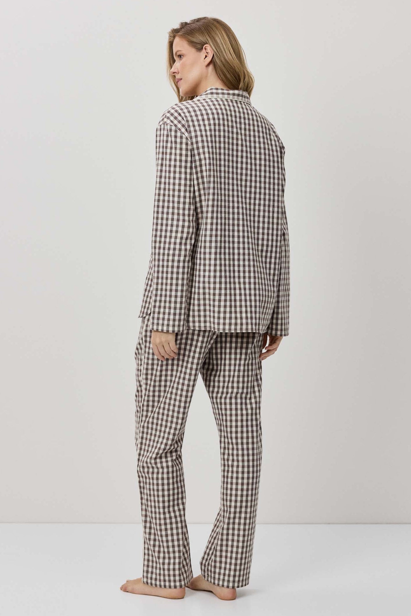 Person wearing a checkered pajama set on a plain background