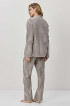 Person wearing a checkered pajama set on a plain background