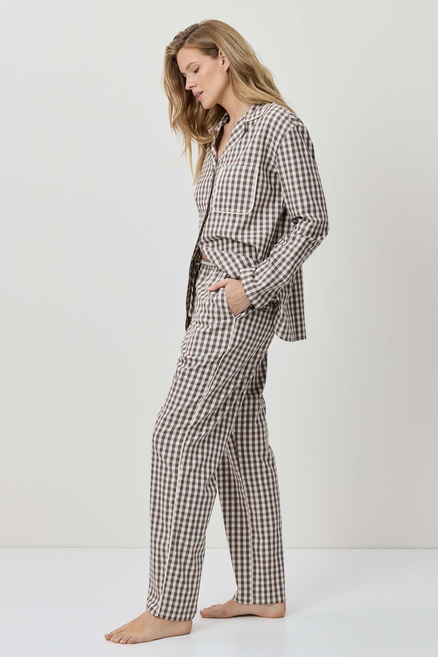 Woman wearing a black and white checkered pajama set on a white background