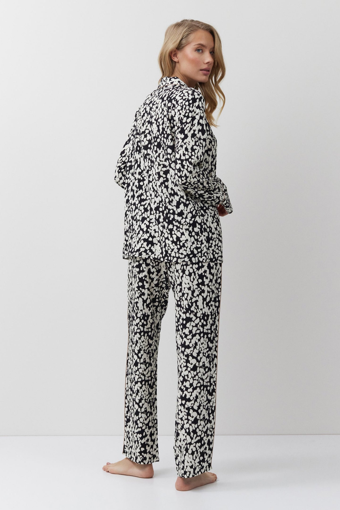 Woman wearing a black and white patterned onesie on a white background