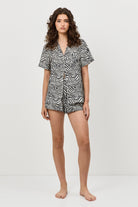 Woman wearing a black and white patterned pajama set on a white background