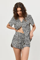 Woman wearing a zebra print pajama set on a white background