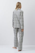 Person wearing a checkered pajama set on a white background