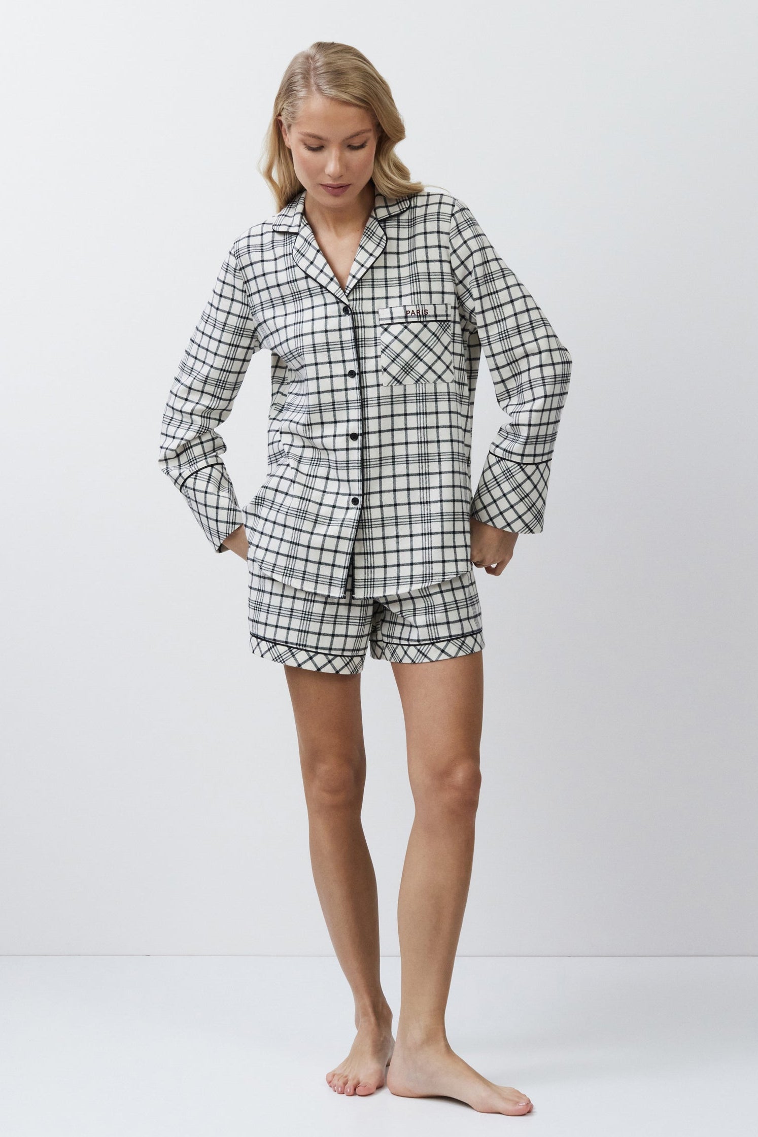 Person wearing a checkered pajama set on a white background