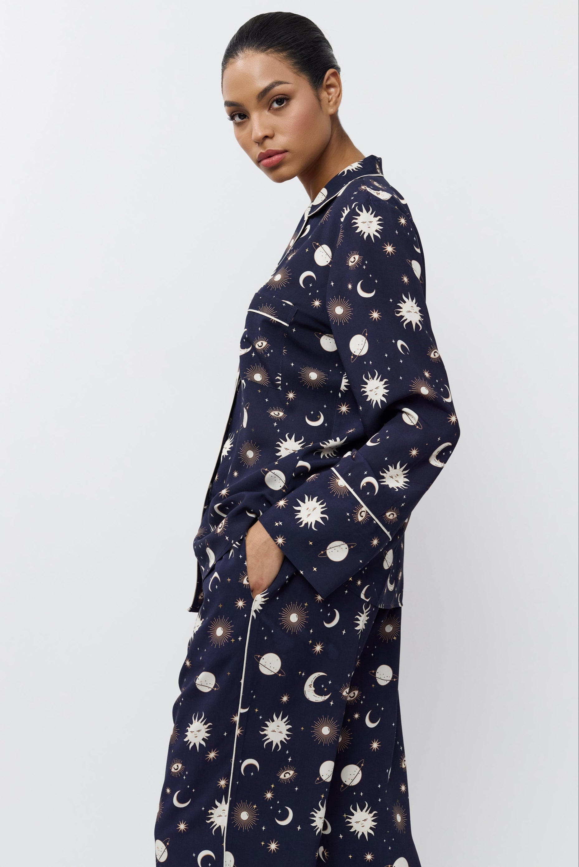 Person wearing a navy pajama set with pattern on a white background