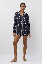 Person wearing a navy blue pajama set with pattern on a white background