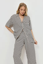 Woman wearing a patterned pajama set on a plain background