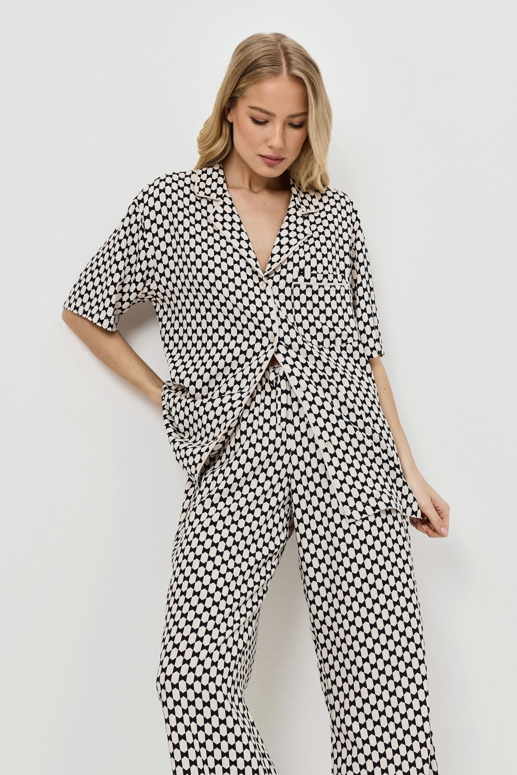 Woman wearing a patterned pajama set on a plain background