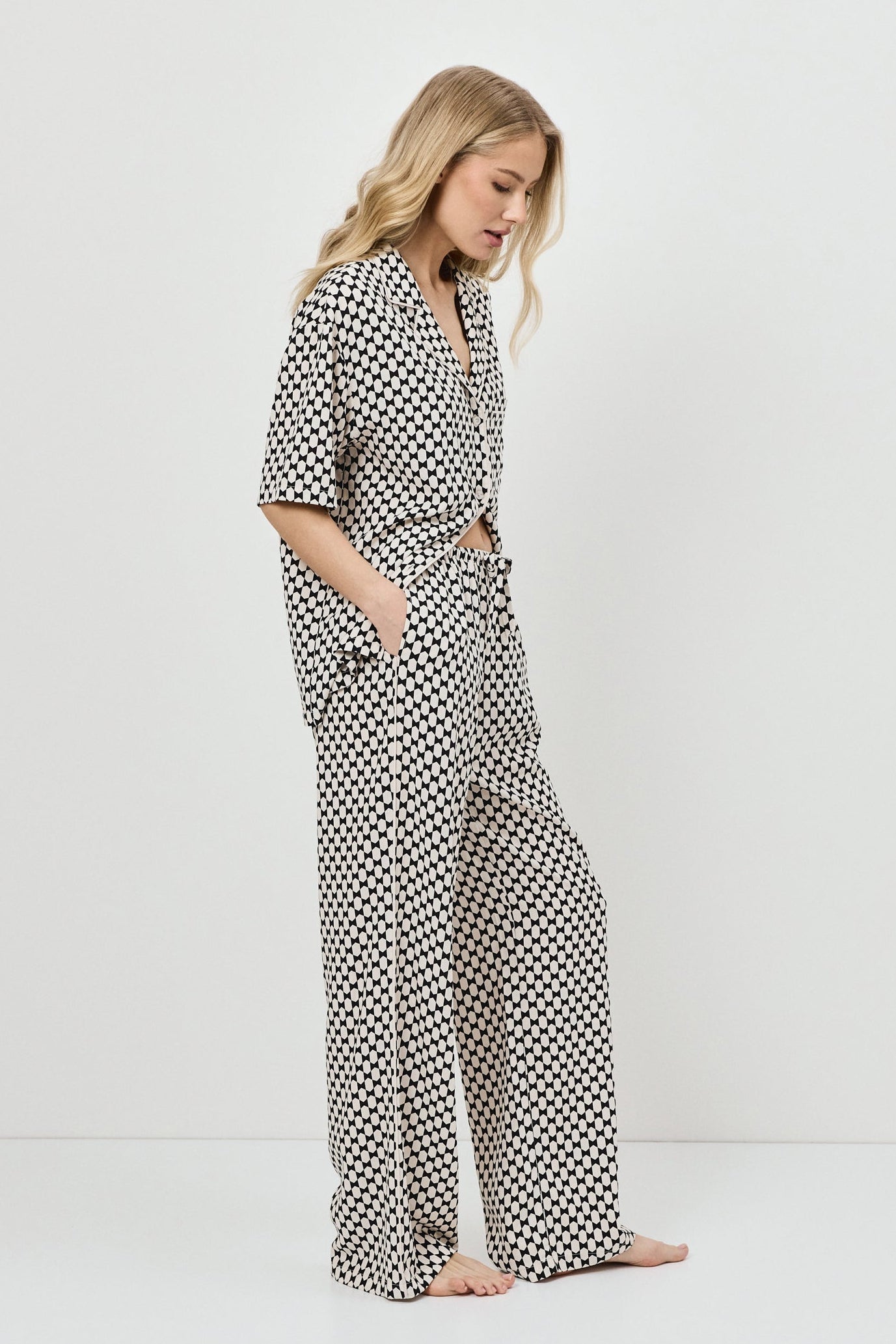 Woman wearing a patterned pajama set on a white background