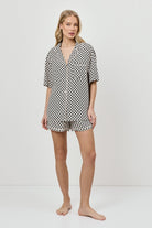 Woman wearing a patterned pajama set on a white background