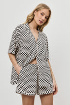 Woman wearing a patterned pajama set on a plain background