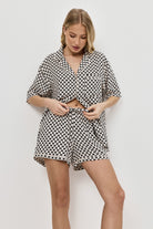 Woman wearing a patterned pajama set on a white background