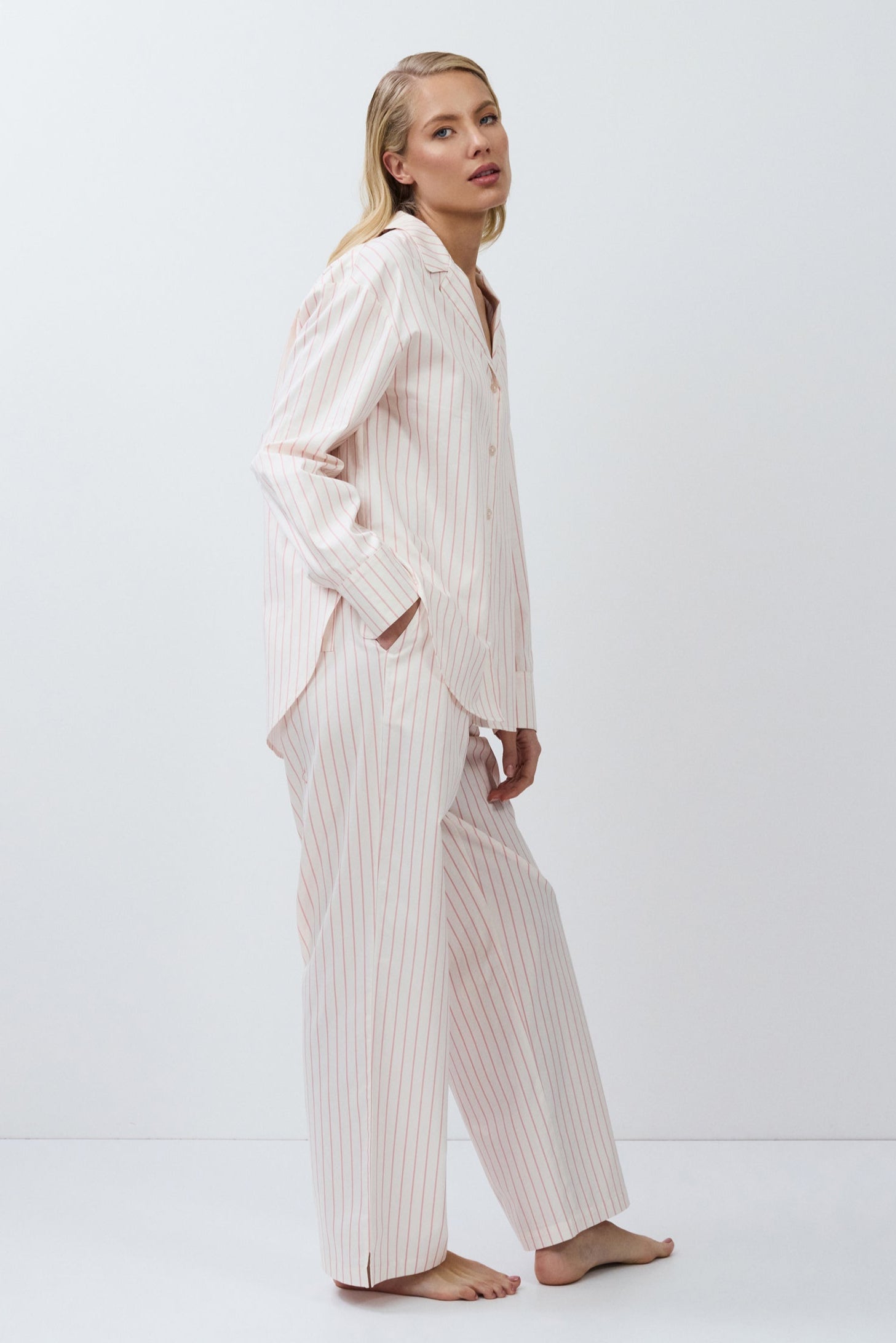 Woman wearing a striped pajama set on a white background